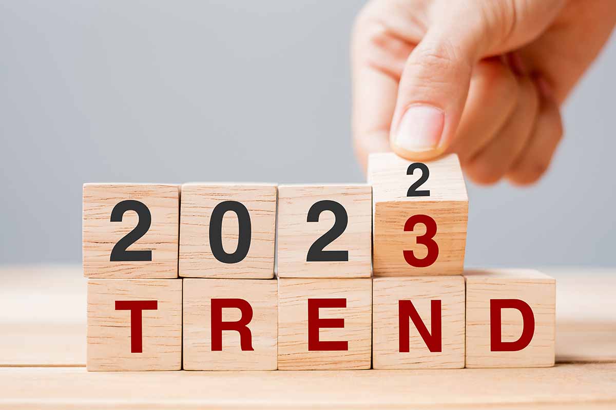 Hand flipping wooden blocks from 2022 to 2023 with the word trend below